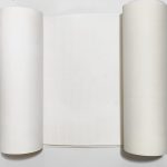 קלף מהודר לספר תורה בגובה 56 ס"מ, פתוח בין שני גלילים לבנים