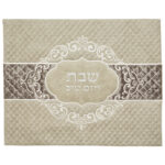 כיסוי חלה מהודר בגוון שמנת עם רקמה לבנה וכיתוב "שבת ויום טוב" בעיצוב קלאסי ואלגנטי.